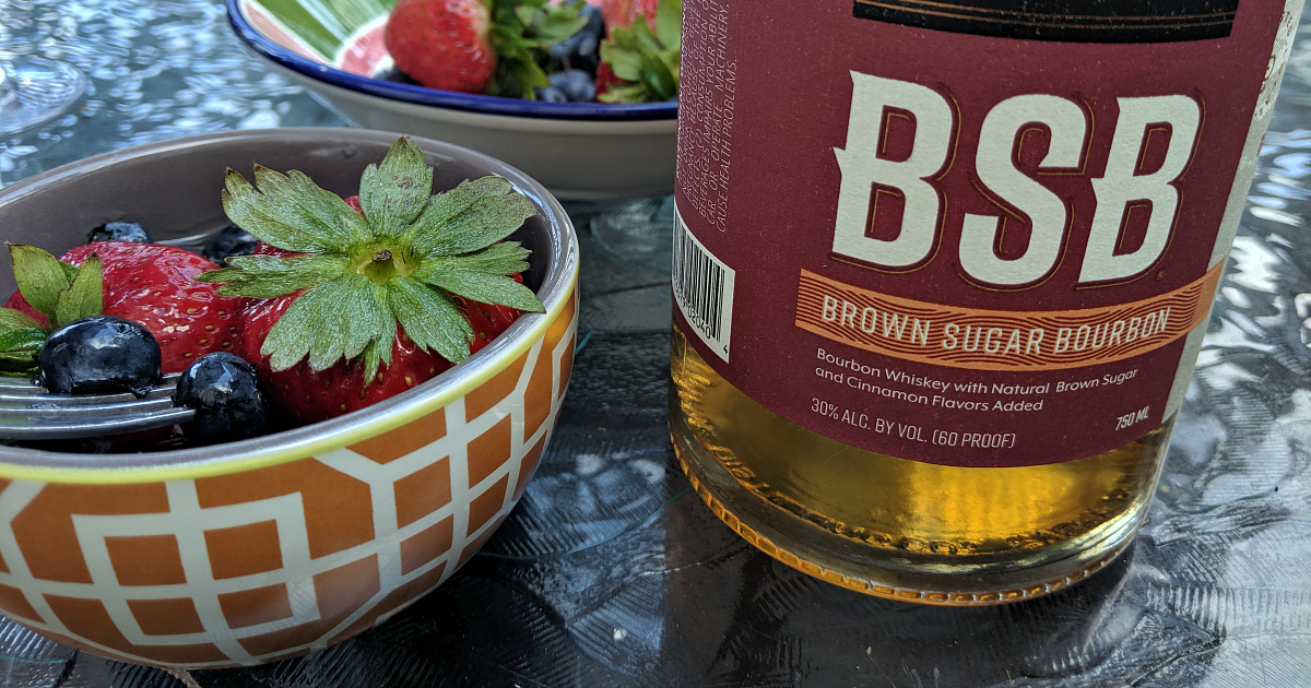 bottle of bourbon next to berries