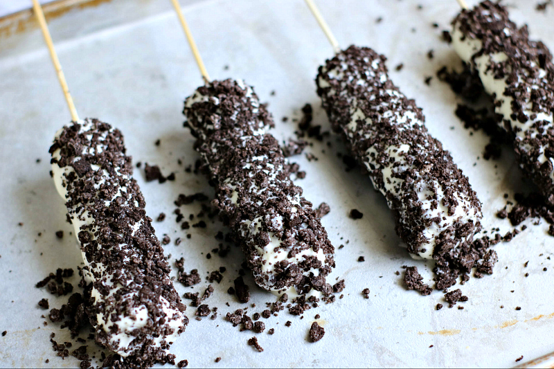 covering marshmallow pops with oreo cookies