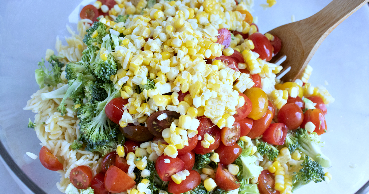 orzo salad ingredients in mixing bowl