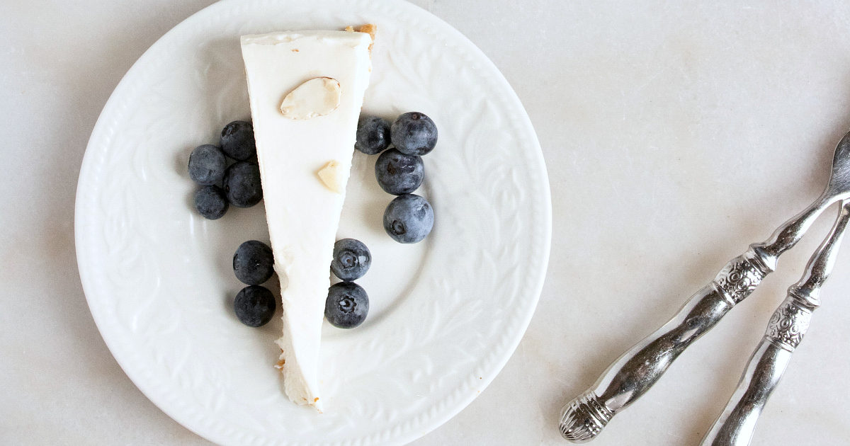 overhead view slice of cheesecake with blueberries and almonds