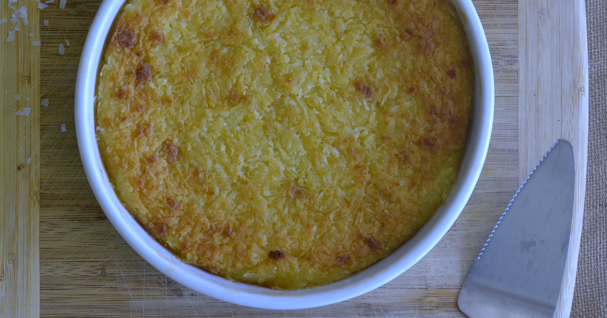 whole coconut pie on cutting board with pie server