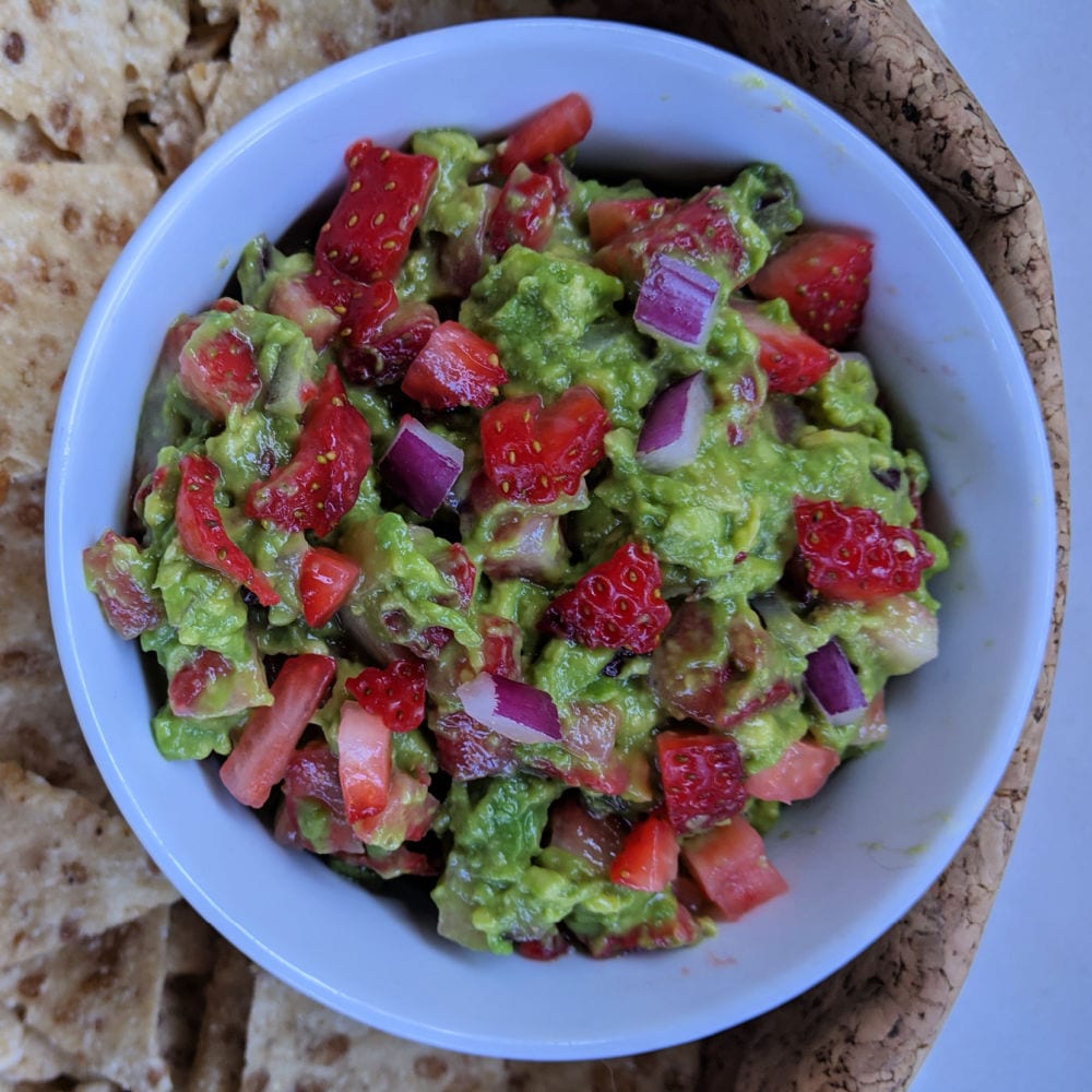 strawberry guacamole in white bowl with chips