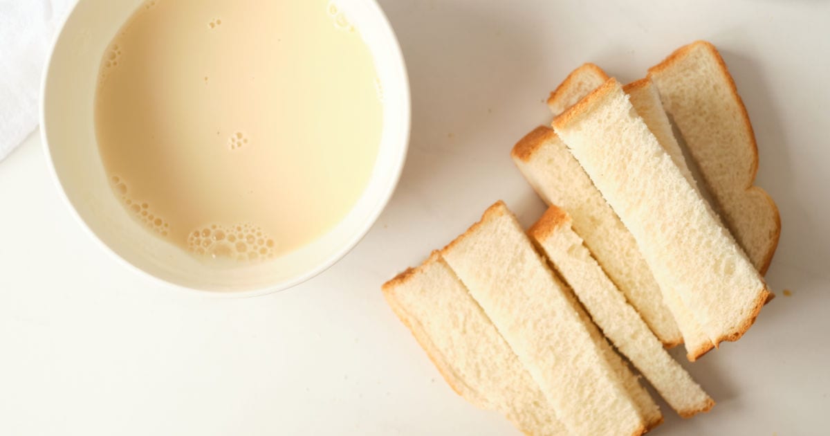 Bowl of French toast liquid and bread cut into sticks.