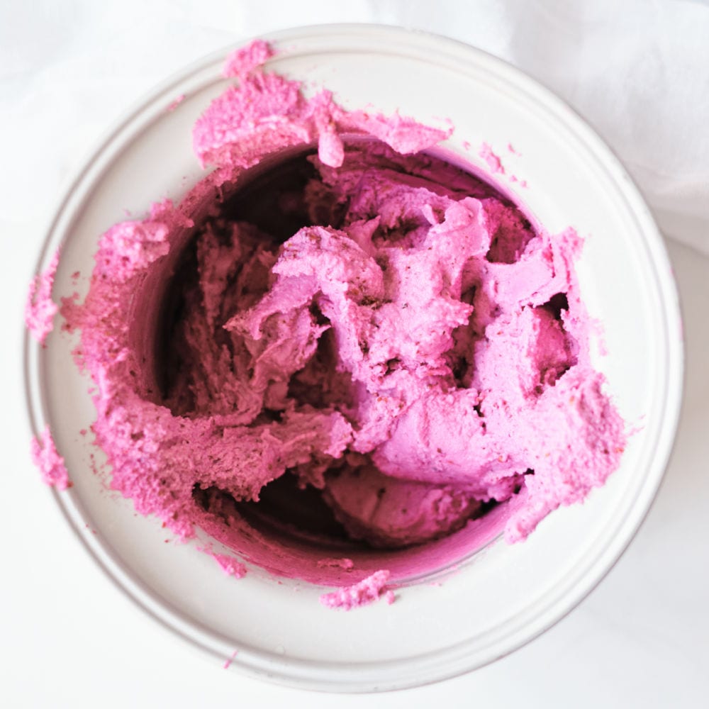 blackberry frozen yogurt in an ice cream maker drum.