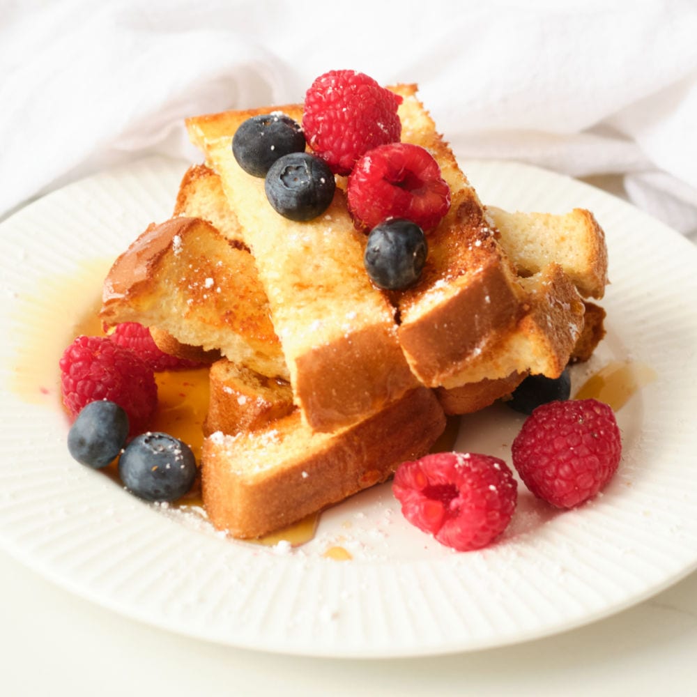 air fryer french toast sticks served with fresh blueberries and raspberries.