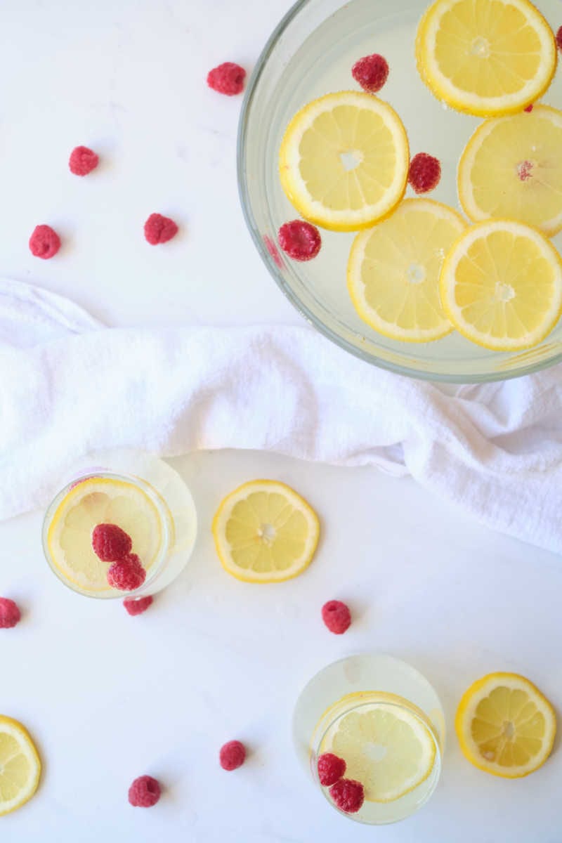 When you want a festive party punch without alcohol, make this sparkling lemonade punch garnished with lemon and raspberries.