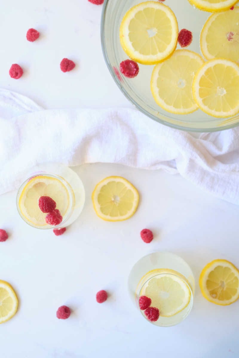 When you want a festive party punch without alcohol, make this sparkling lemonade punch garnished with lemon and raspberries.