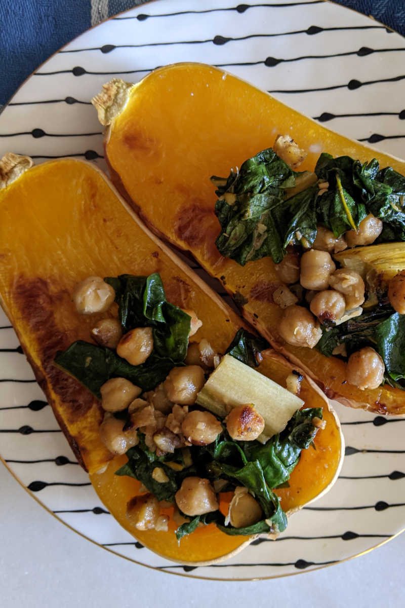 This vegan stuffed butternut squash is roasted is filled with a flavorful mix of chard and chickpeas, so it is delicious.