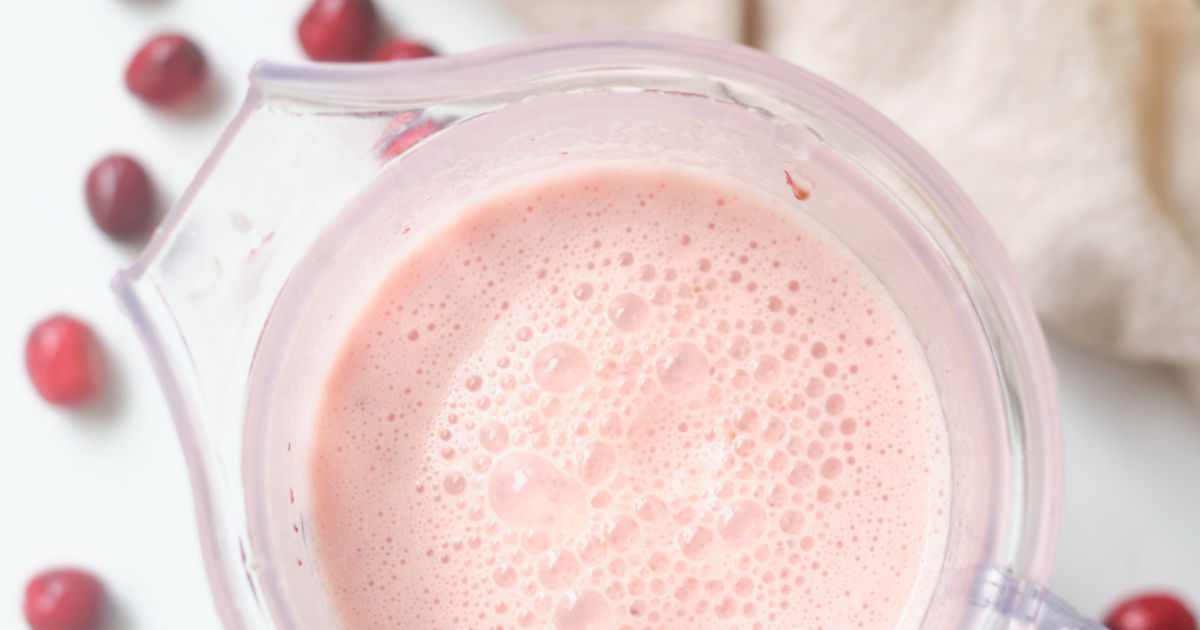 making a creamy cranberry smoothie in a blender