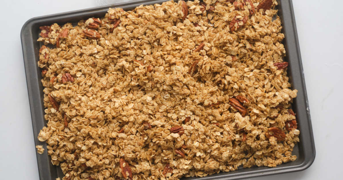 slow cooker granola spread out to cool on pan