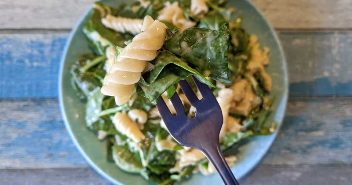rotini and spinach on fork