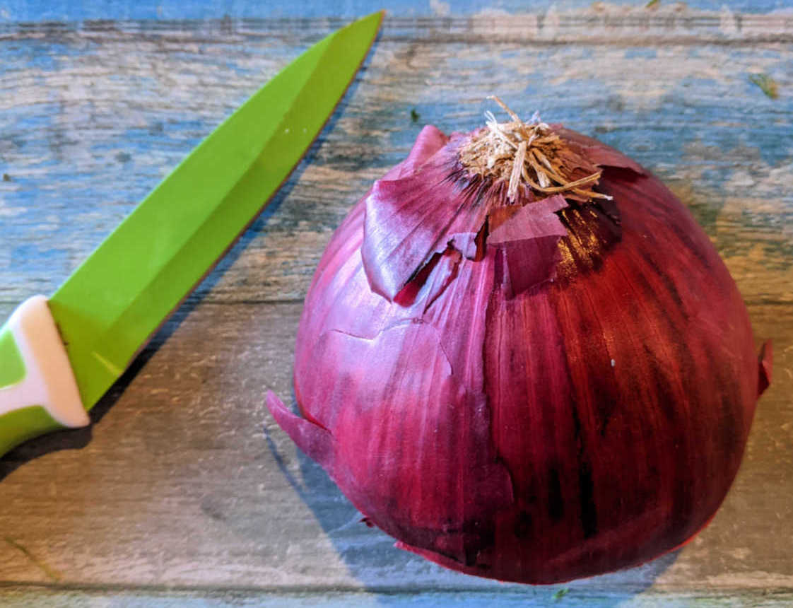 half red onion with knife