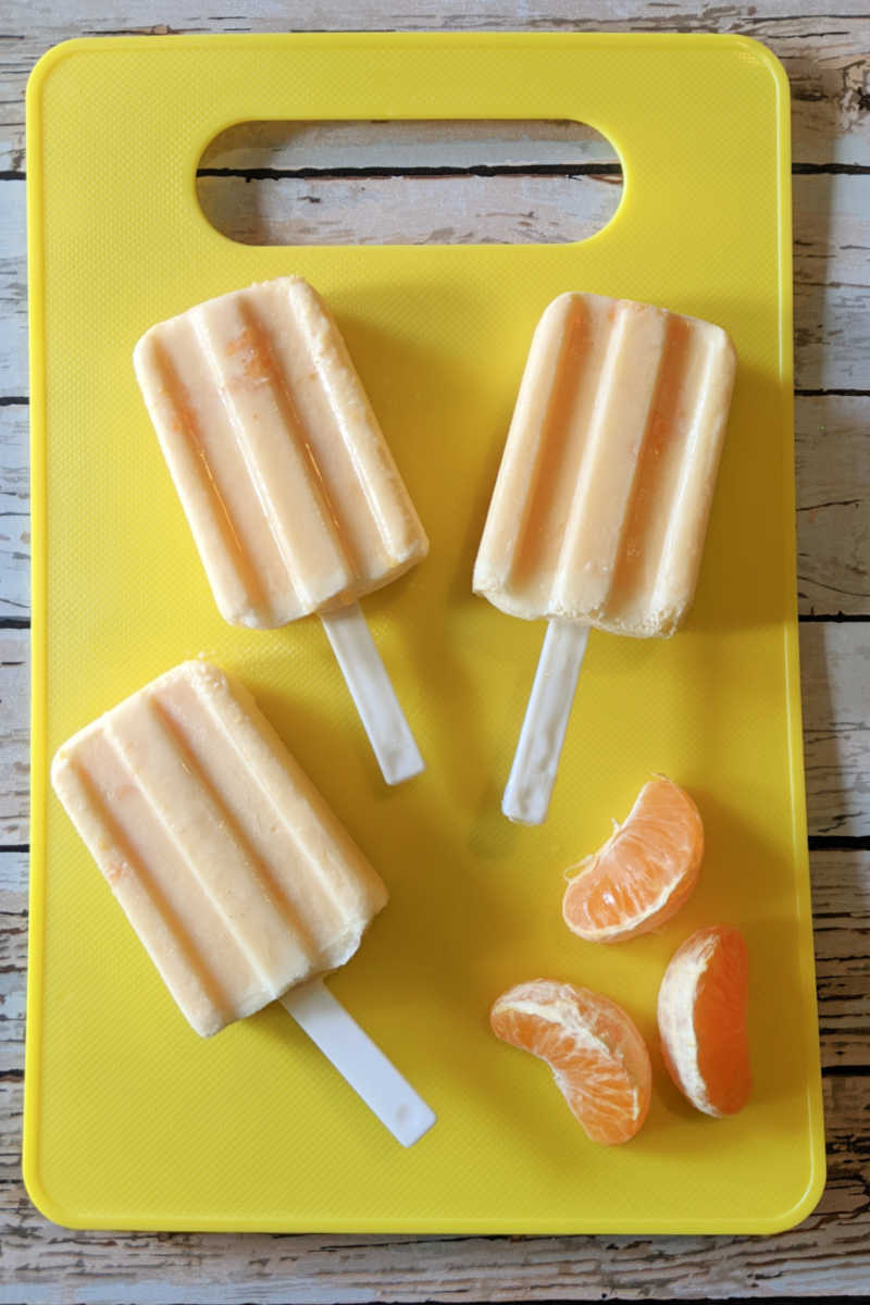 Beat the heat with these vibrant homemade tangerine yogurt popsicles! Tangy tangerines blend with creamy yogurt for a delicious and healthy treat that's packed with vitamin C and protein.