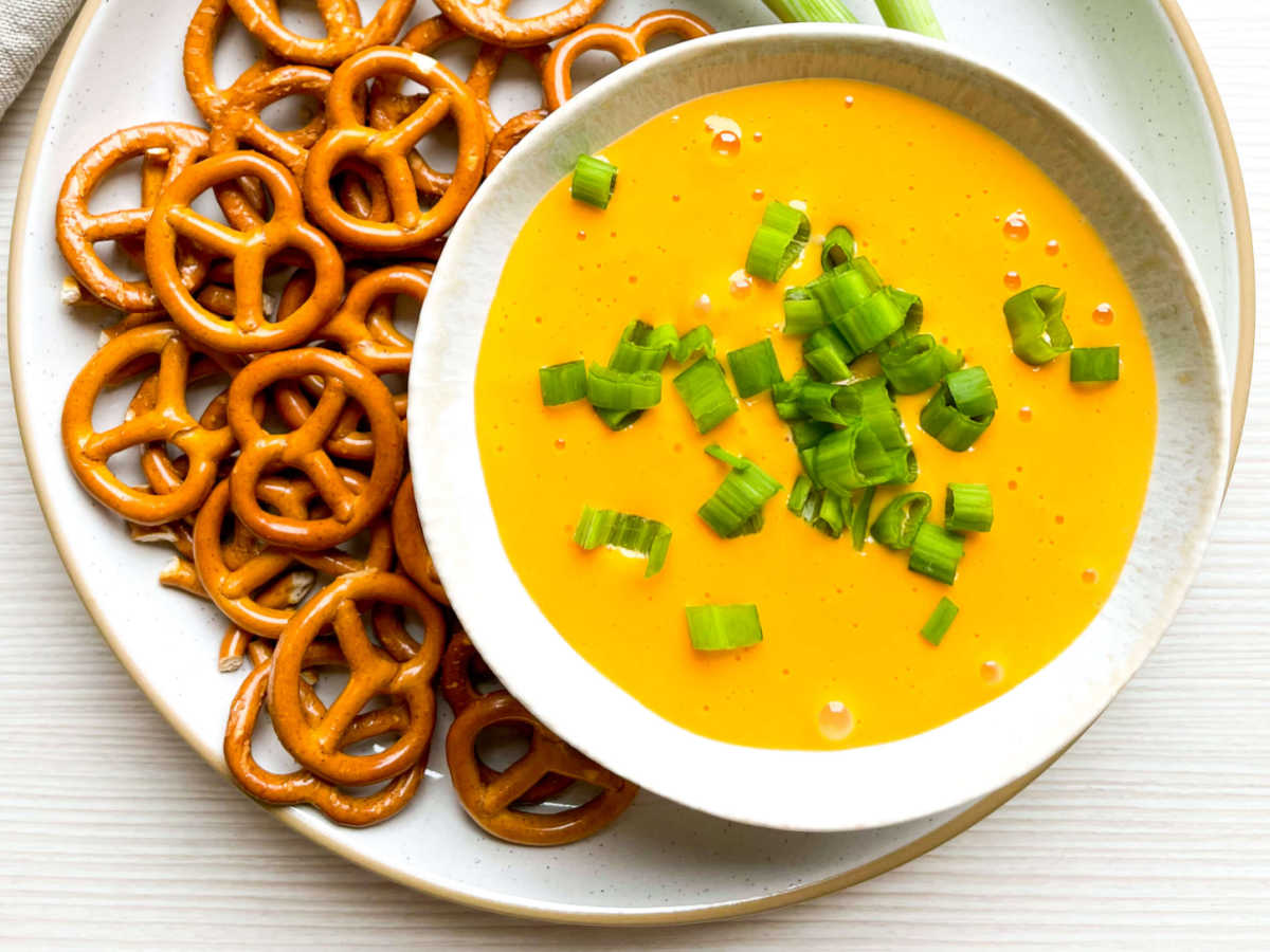 bowl of warm beer cheese dip and pretzels