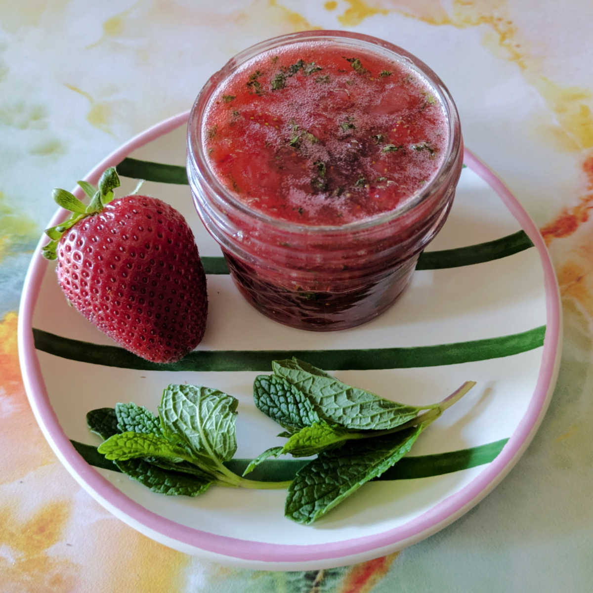 jar of strawberry mint jam on plate