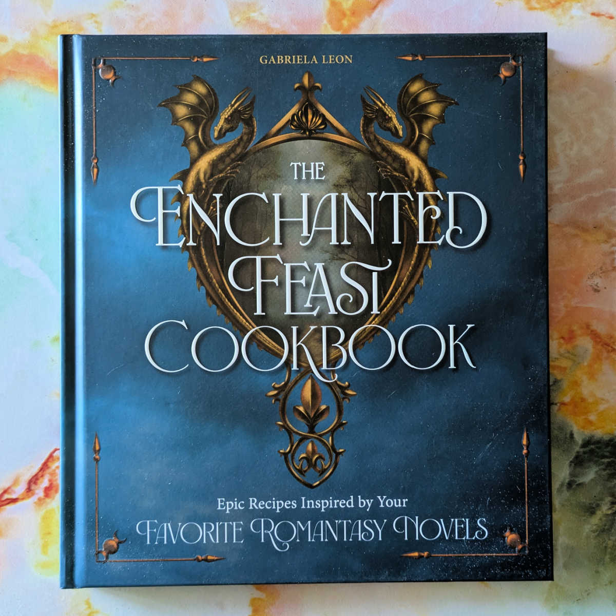 The Enchanted Feast Cookbook is very fun and magical for fans of romantasy novels! This whimsical cookbook features epic, themed recipes perfect for a party or your regular rotation. Makes a beautiful gift book!